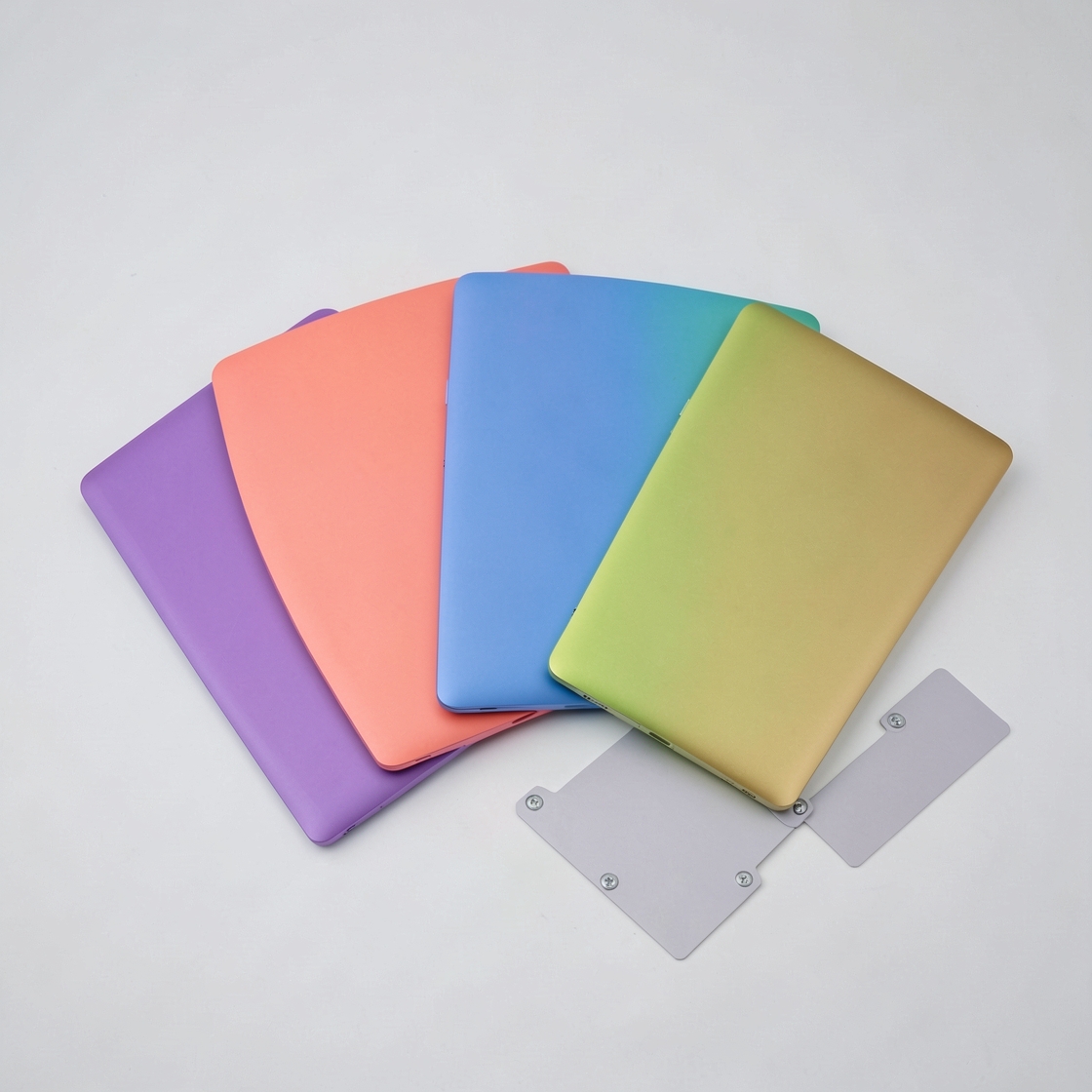 A row of colorful unbranded laptops with blank screens in a clean design studio